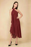 Front view of the LVLVS Alma rust midi dress, showing the asymmetric neckline, draped neck scarf and flowing uneven hem.