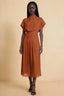 Front view of the LVLVS Alva burnt orange midi dress, showing the high draped neckline, short sleeves and wide fitted waist panel.