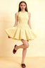 Lemon yellow Cheryl crepe dress with round neck and flared skater skirt, model posing in studio for semi-formal party look.