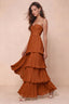 Front studio view of Sonia rust tiered pleated maxi dress with a long flowing skirt