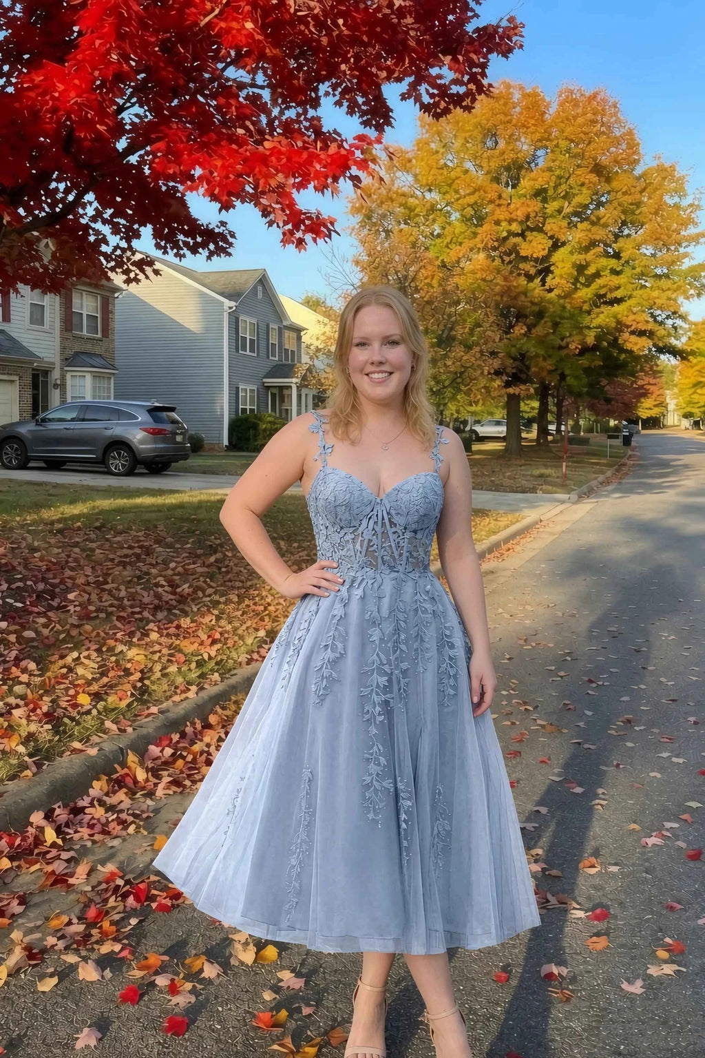 Front view of the LVLVS Adeline dusty blue midi dress on an autumn street, with red and yellow leaves in the background.