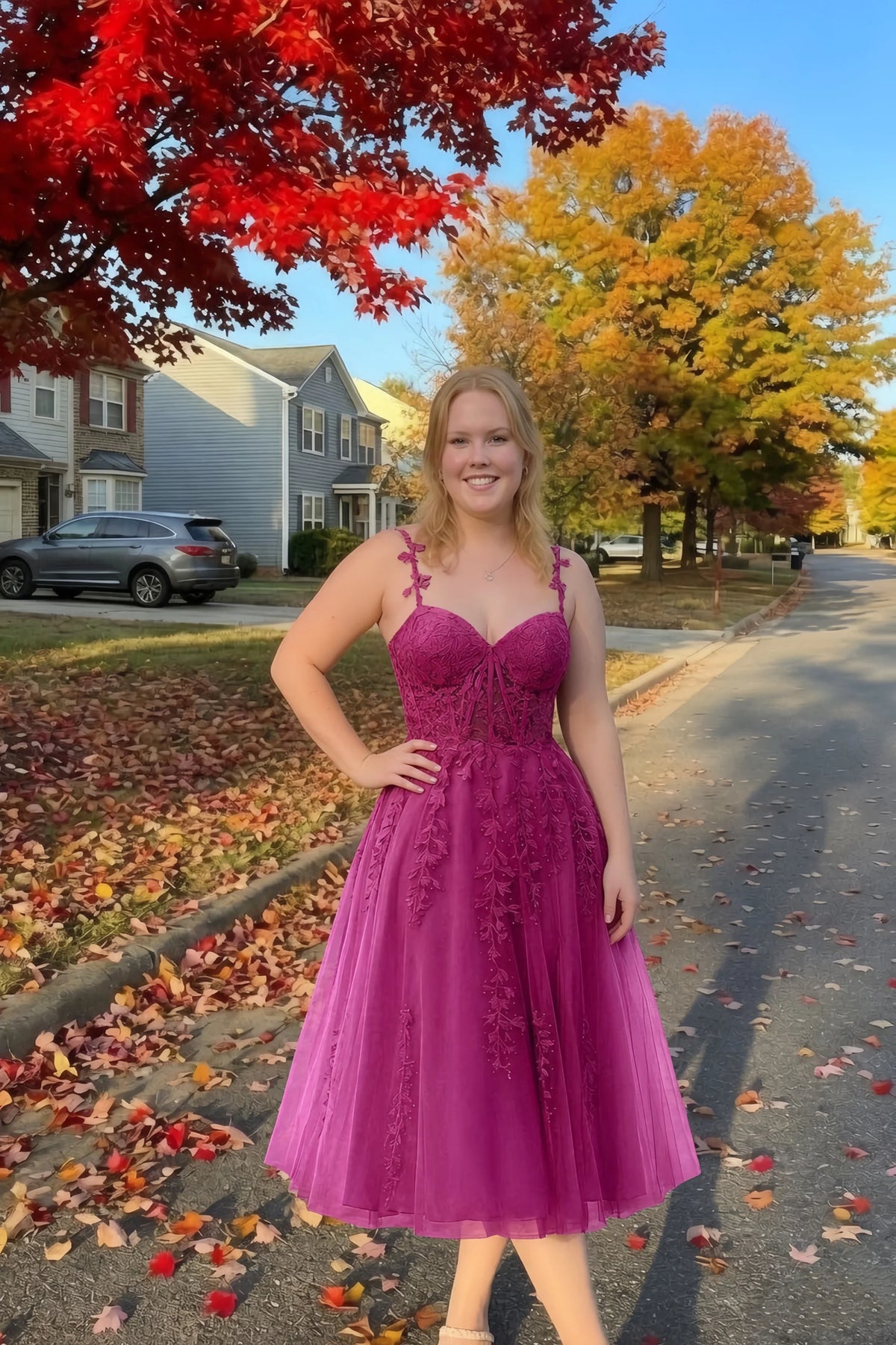 Front view of the LVLVS Adeline fuchsia midi dress on an autumn street, with red and yellow leaves in the background.