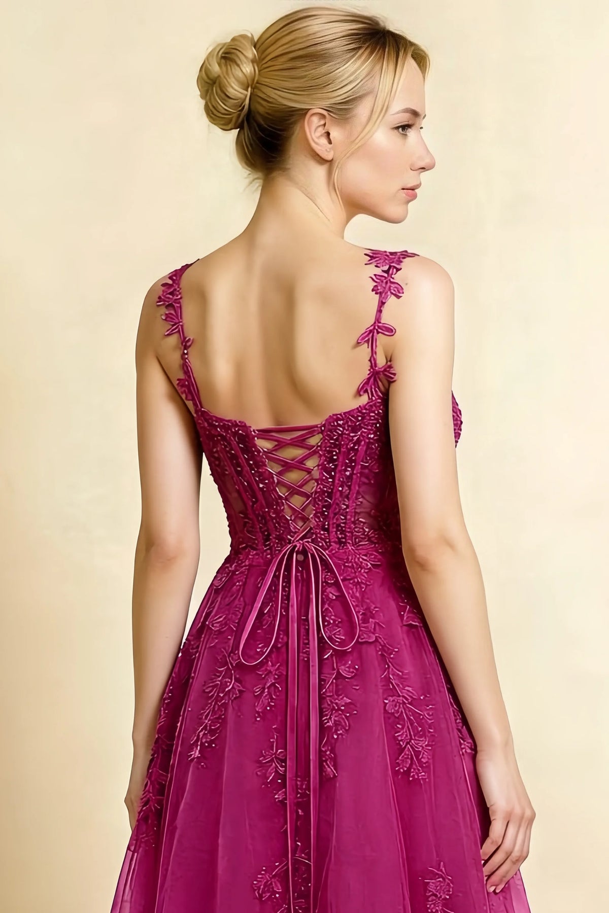 Rear three-quarter detail of the LVLVS Adeline fuchsia midi dress, showing the corset lacing, tied bow and floral lace straps.
