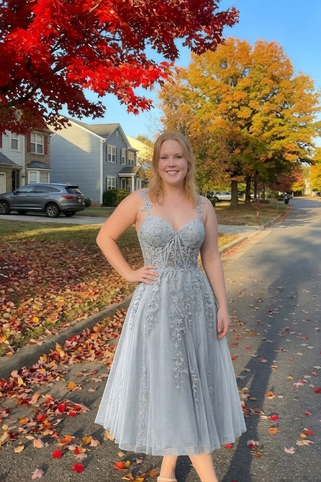 Front view of the LVLVS Adeline silver midi dress on an autumn street, with red and yellow leaves in the background.