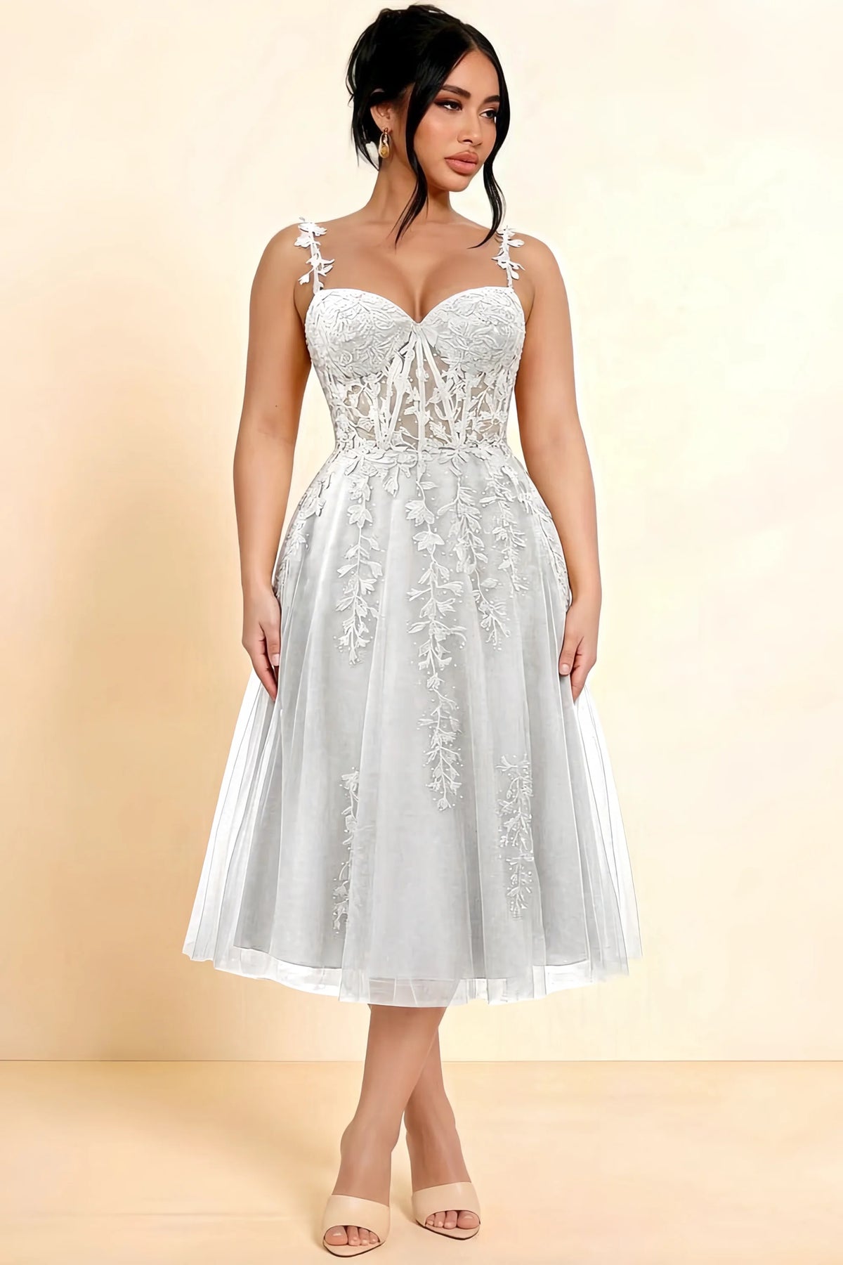 Full-length view of a model wearing the LVLVS Adeline white midi dress, showing the fitted lace bodice and flared calf-length skirt.