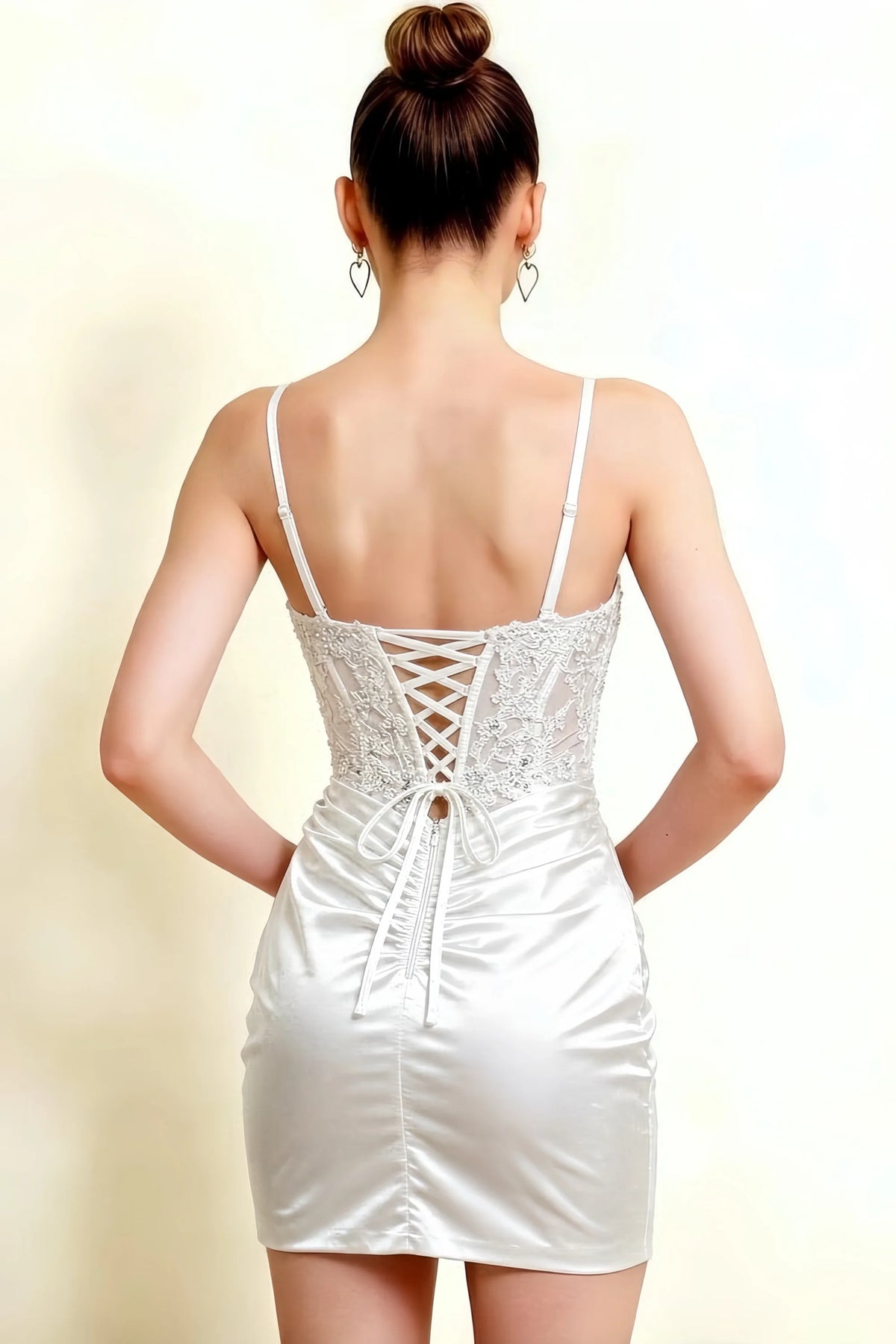 White Andrea bodycon sweetheart neck mini dress with slit, back view featuring delicate lace-up corset back and thin detachable straps, satin fabric, studio shot for formal event or party wear