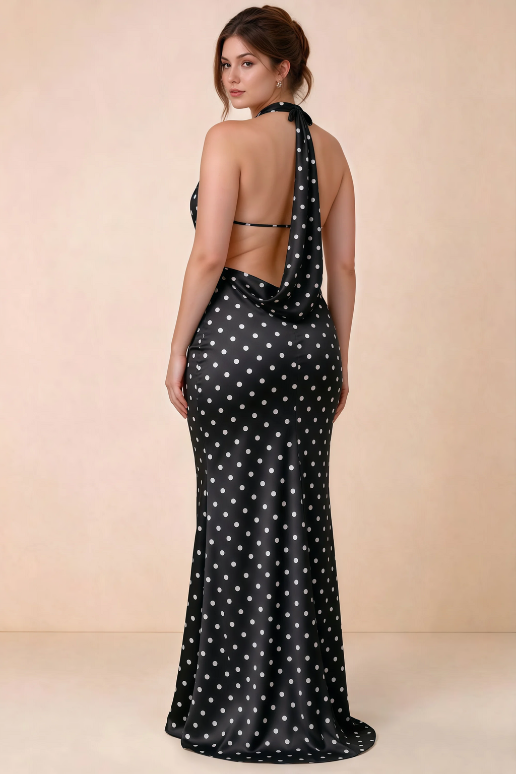 Three-quarter rear view of Astrid black polka dot halter maxi dress, highlighting the cowl back.