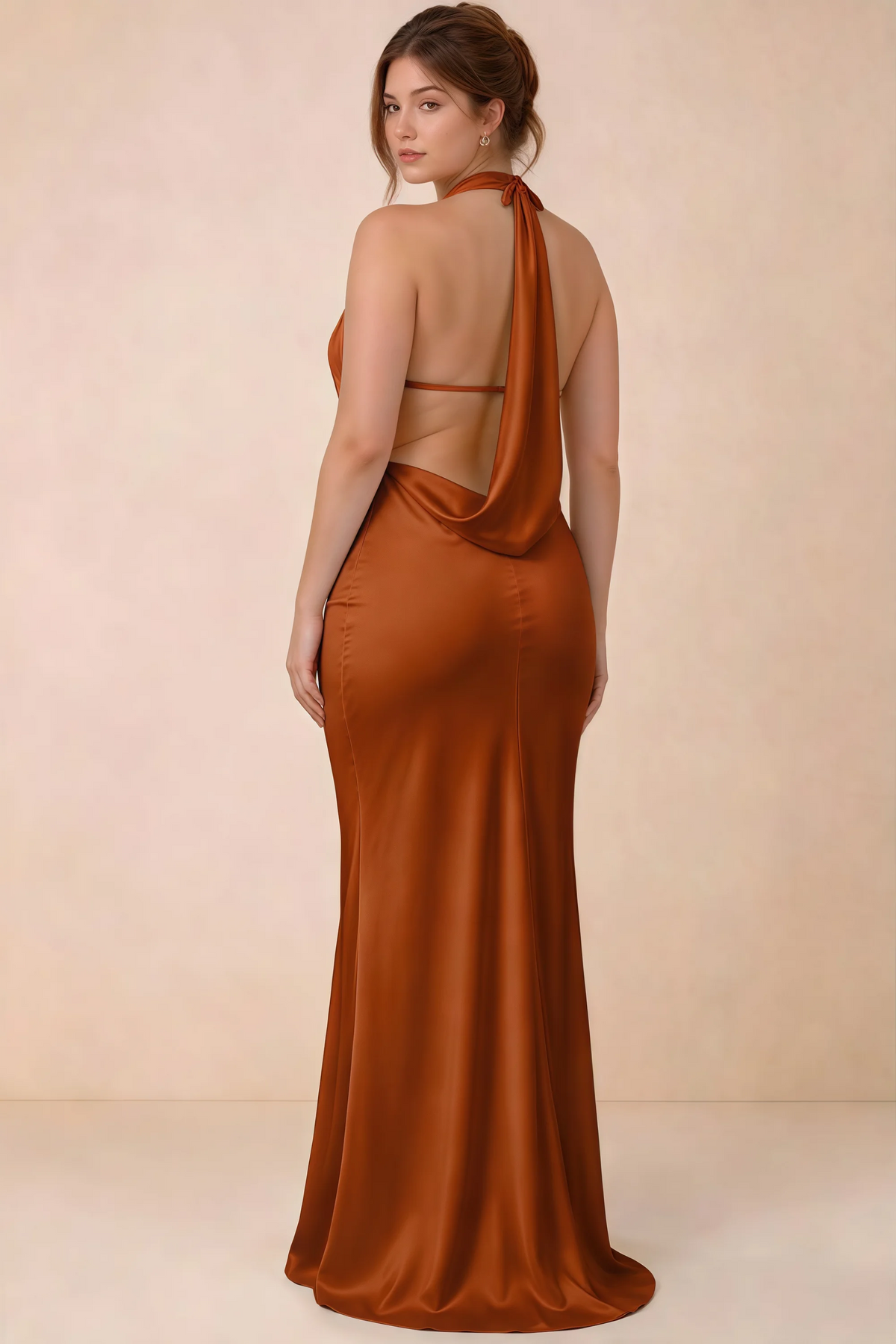 Rear three-quarter view of the Astrid burnt orange satin maxi dress, showing the halter ties, slim back strap and cowl detail.