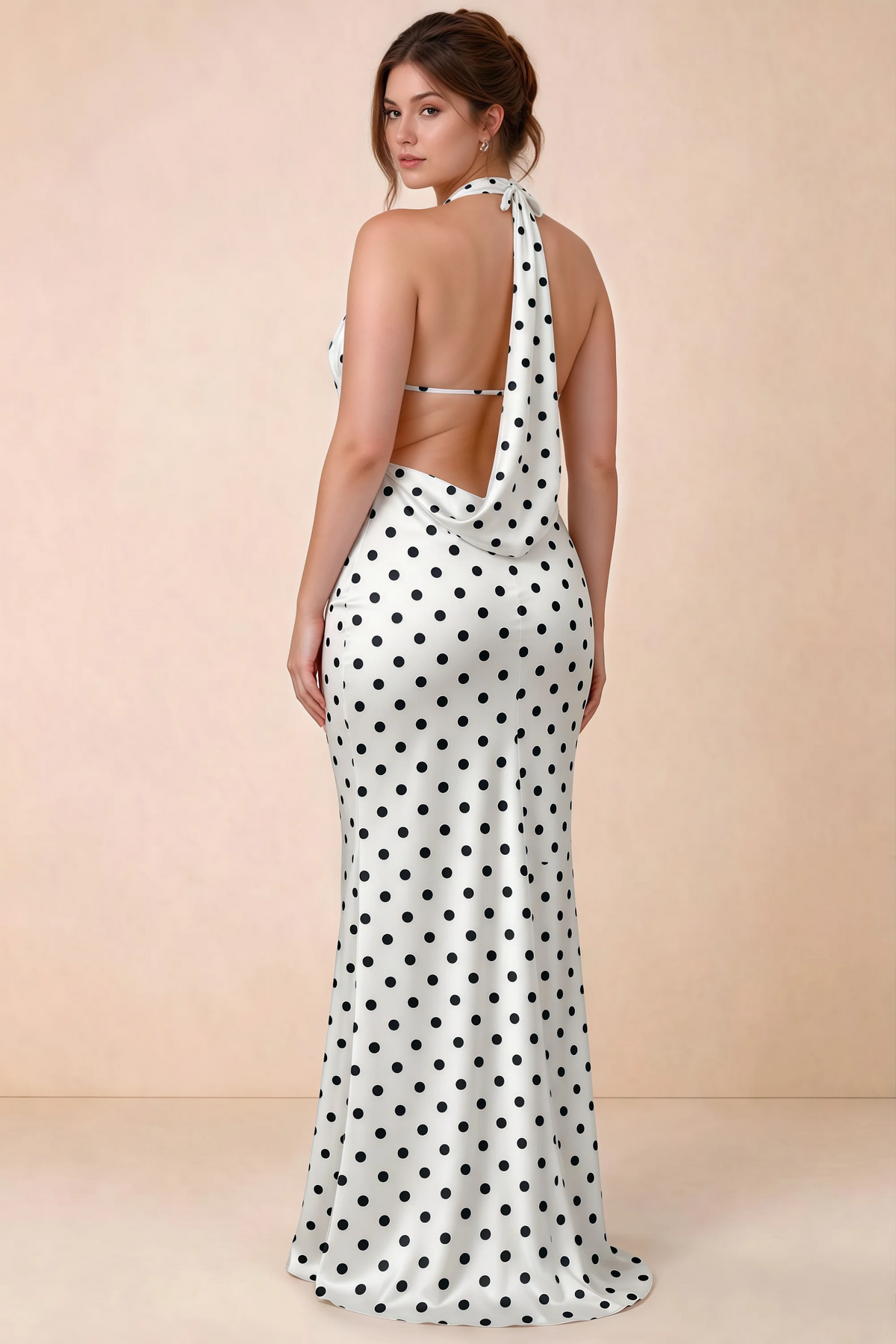 Three-quarter rear view of Astrid white polka dot halter maxi dress, highlighting the cowl back.
