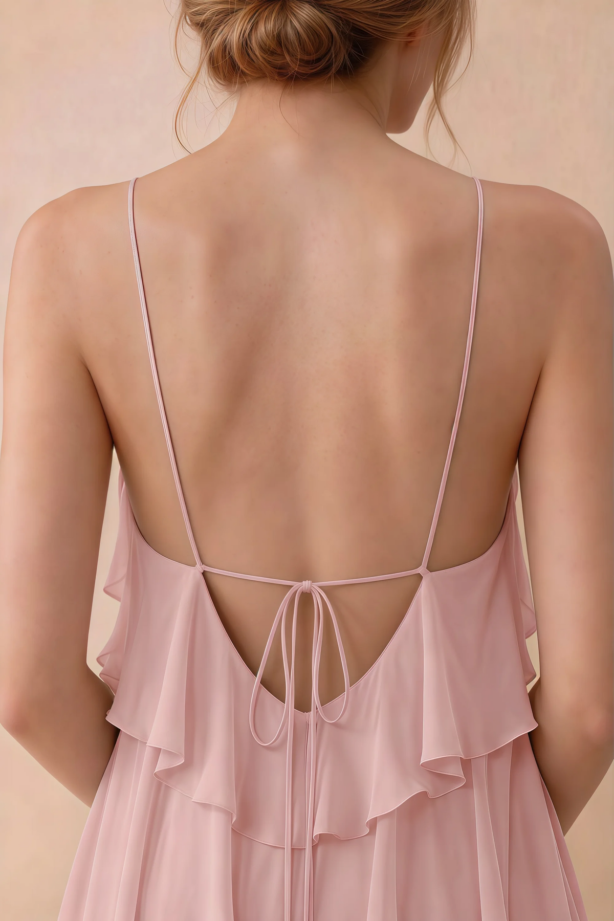 Close-up of Audrey powder pink open back with fine straps tied in a small bow