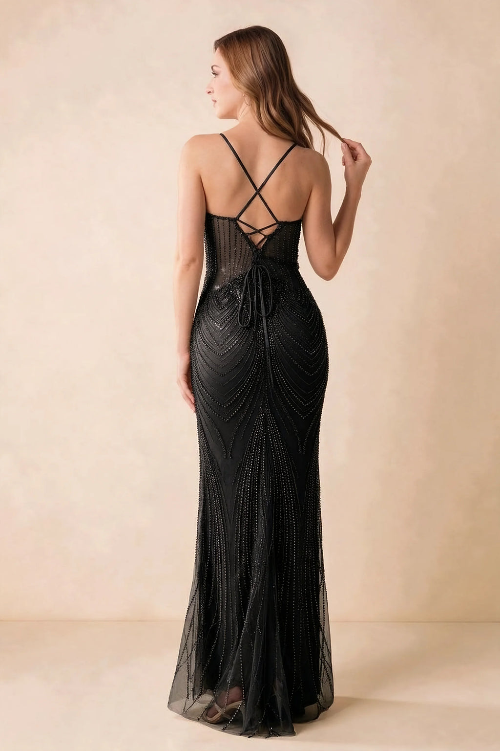Back view of the Augusta black maxi dress showing crossed straps, lace-up ties and a flared hem.