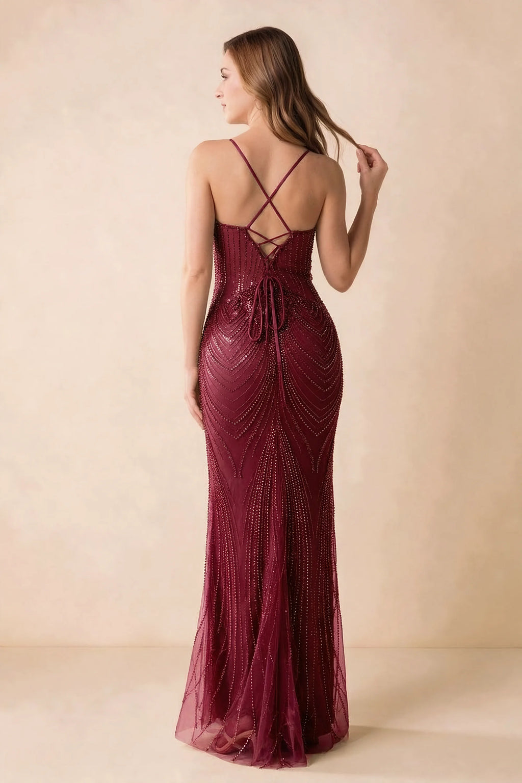 Back view of the Augusta burgundy maxi dress showing crossed straps, lace-up ties and a flared hem.