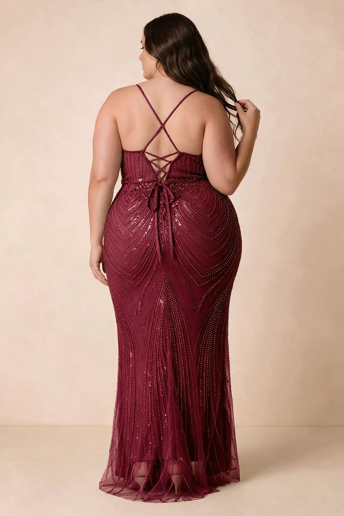 Back view on a second model of the Augusta burgundy dress, showing crisscross straps and tie fastening.