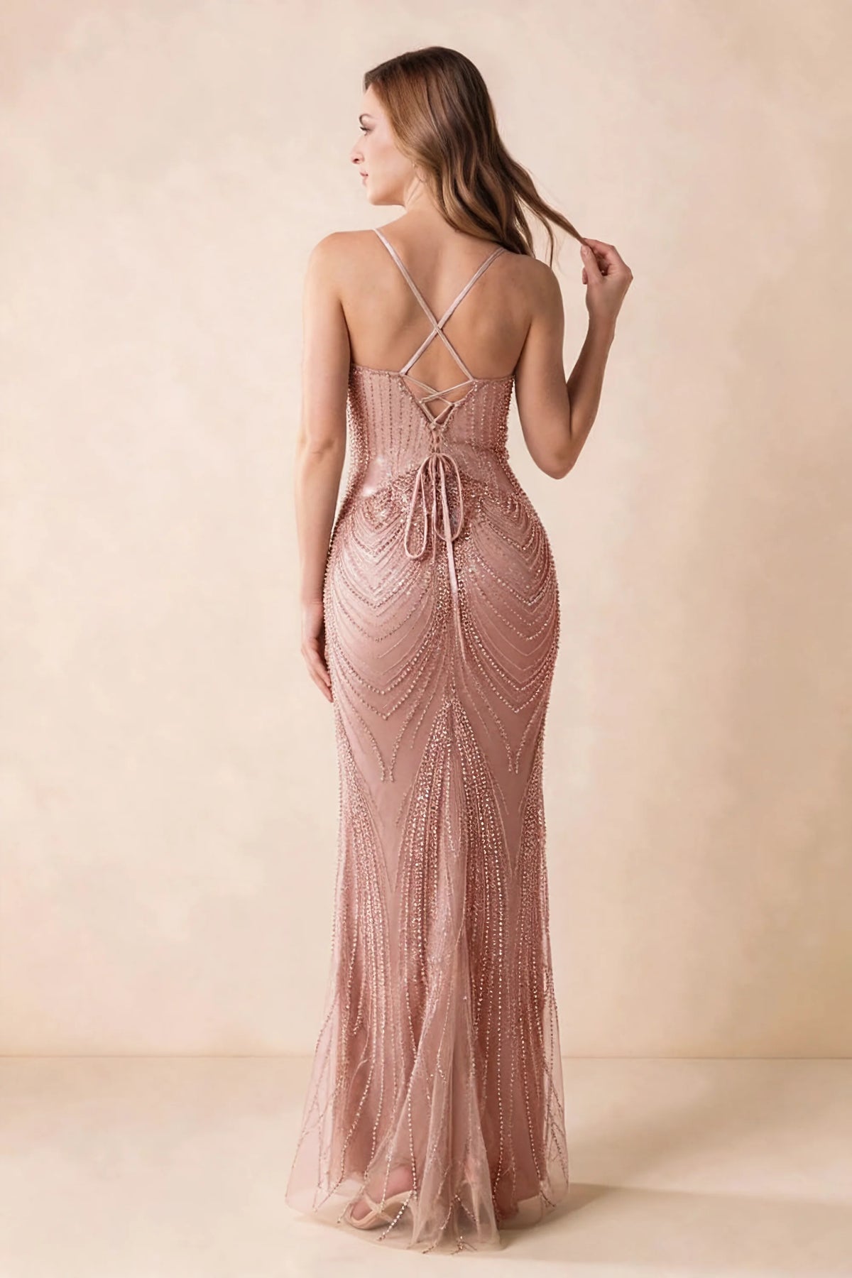 Back view of the Augusta dusty pink maxi dress showing crossed straps, lace-up ties and a flared hem.