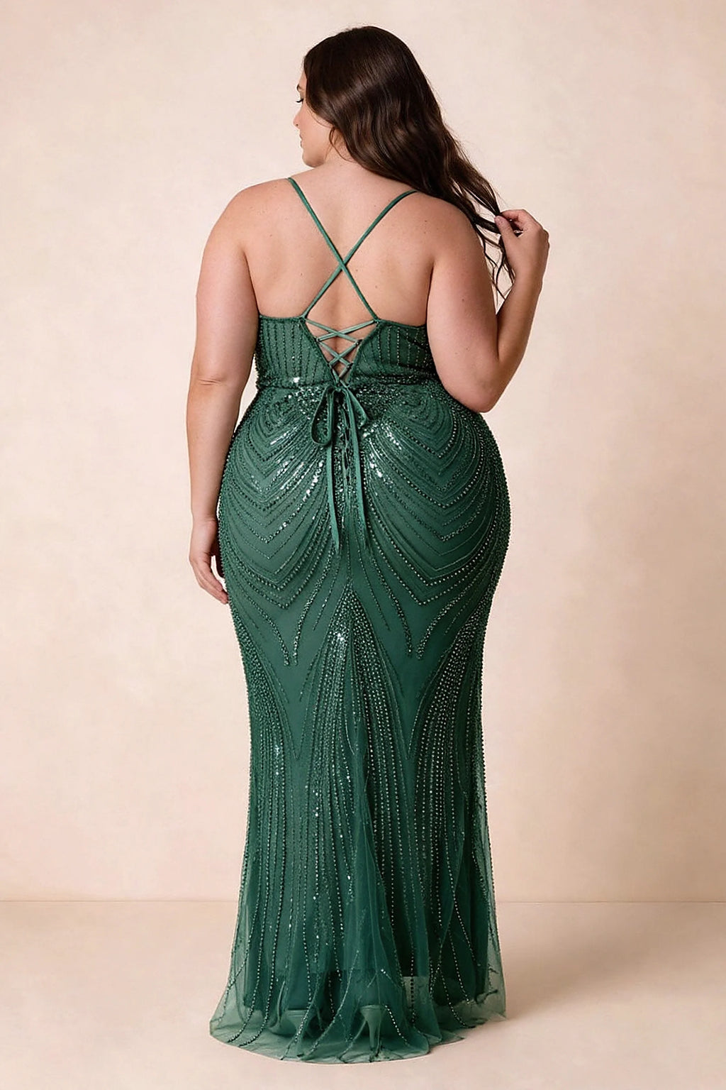 Back view on a second model of the Augusta emerald dress, showing crisscross straps and tie fastening.