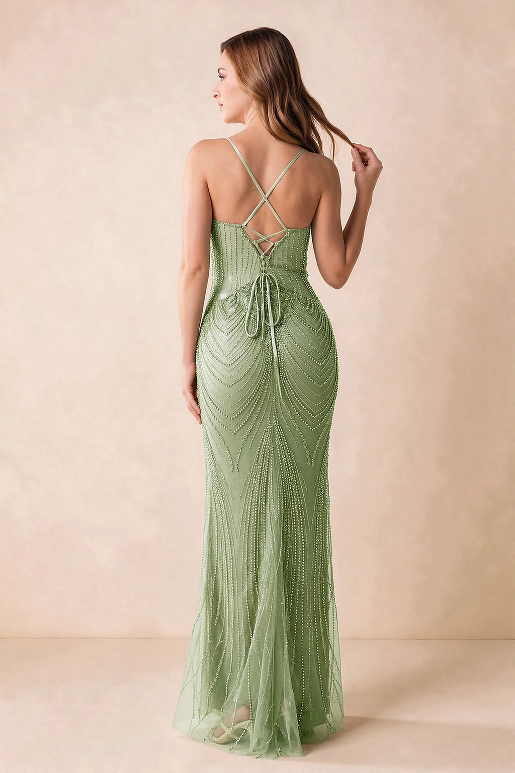 Back view of the Augusta light green maxi dress showing crossed straps, lace-up ties and a flared hem.