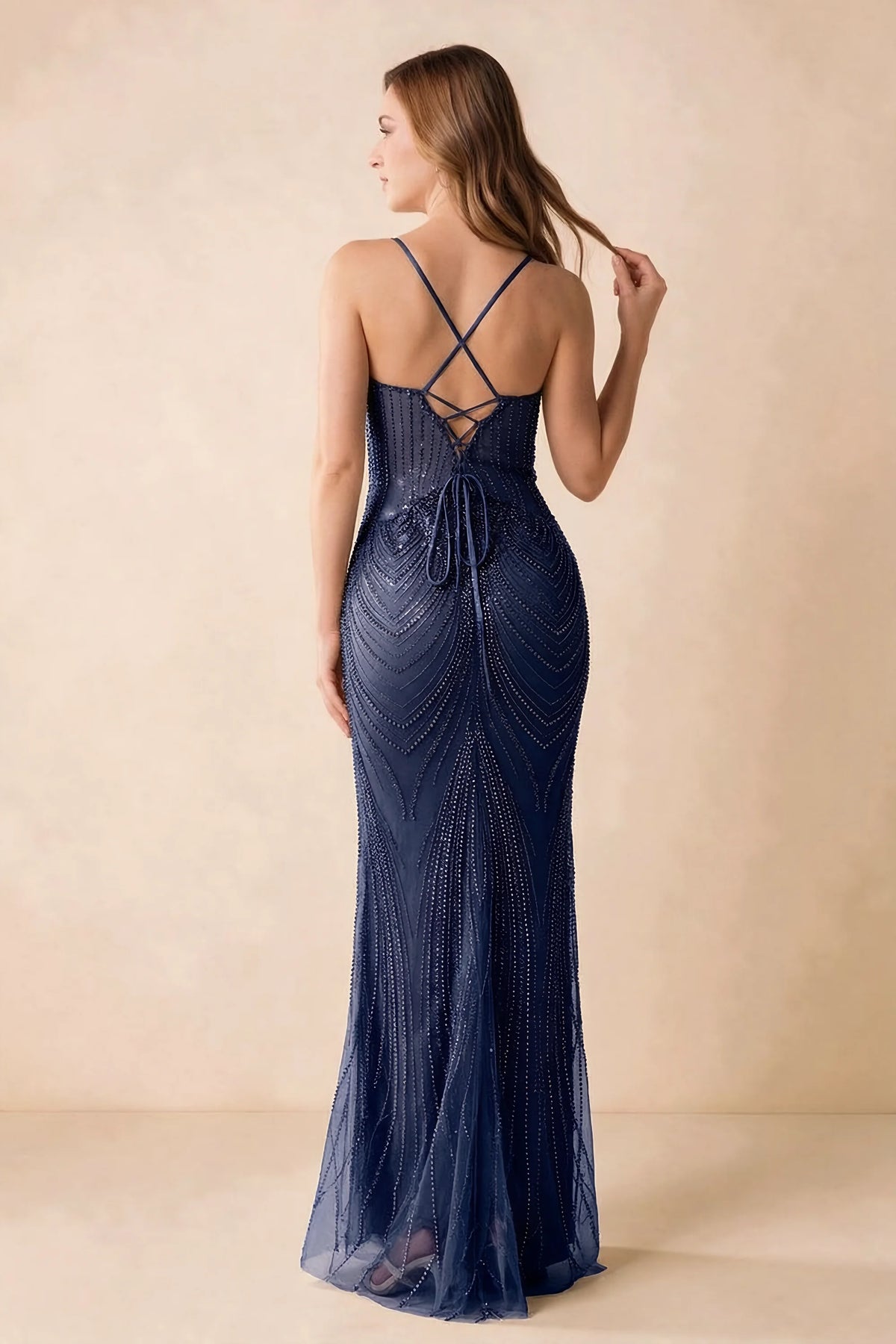 Back view of the Augusta navy maxi dress showing crossed straps, lace-up ties and a flared hem.