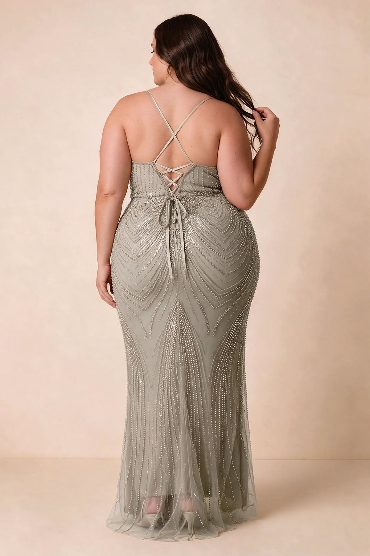 Back view on a second model of the Augusta silver dress, showing crisscross straps and tie fastening.