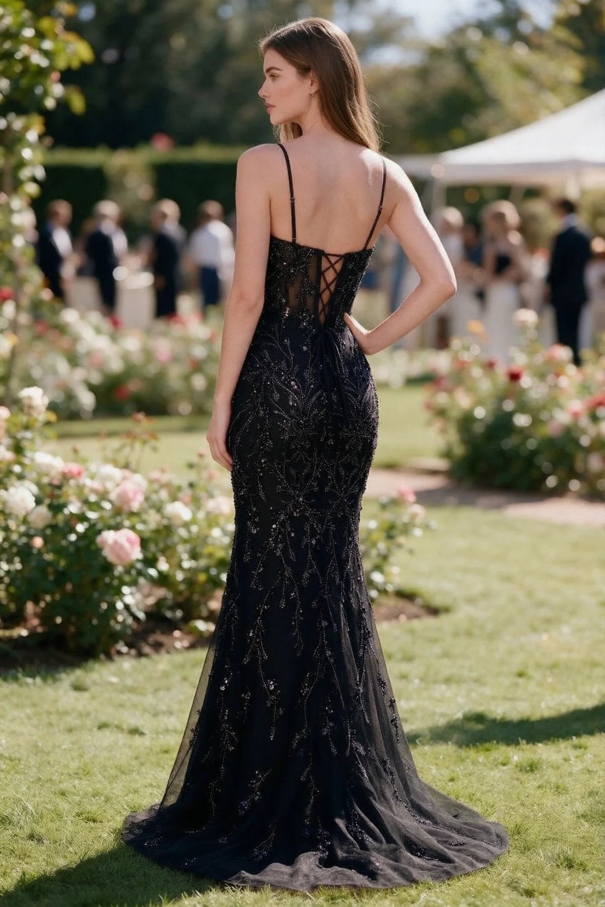 Rear garden view of Aurelia black mermaid dress with an open upper back and lace-up waist