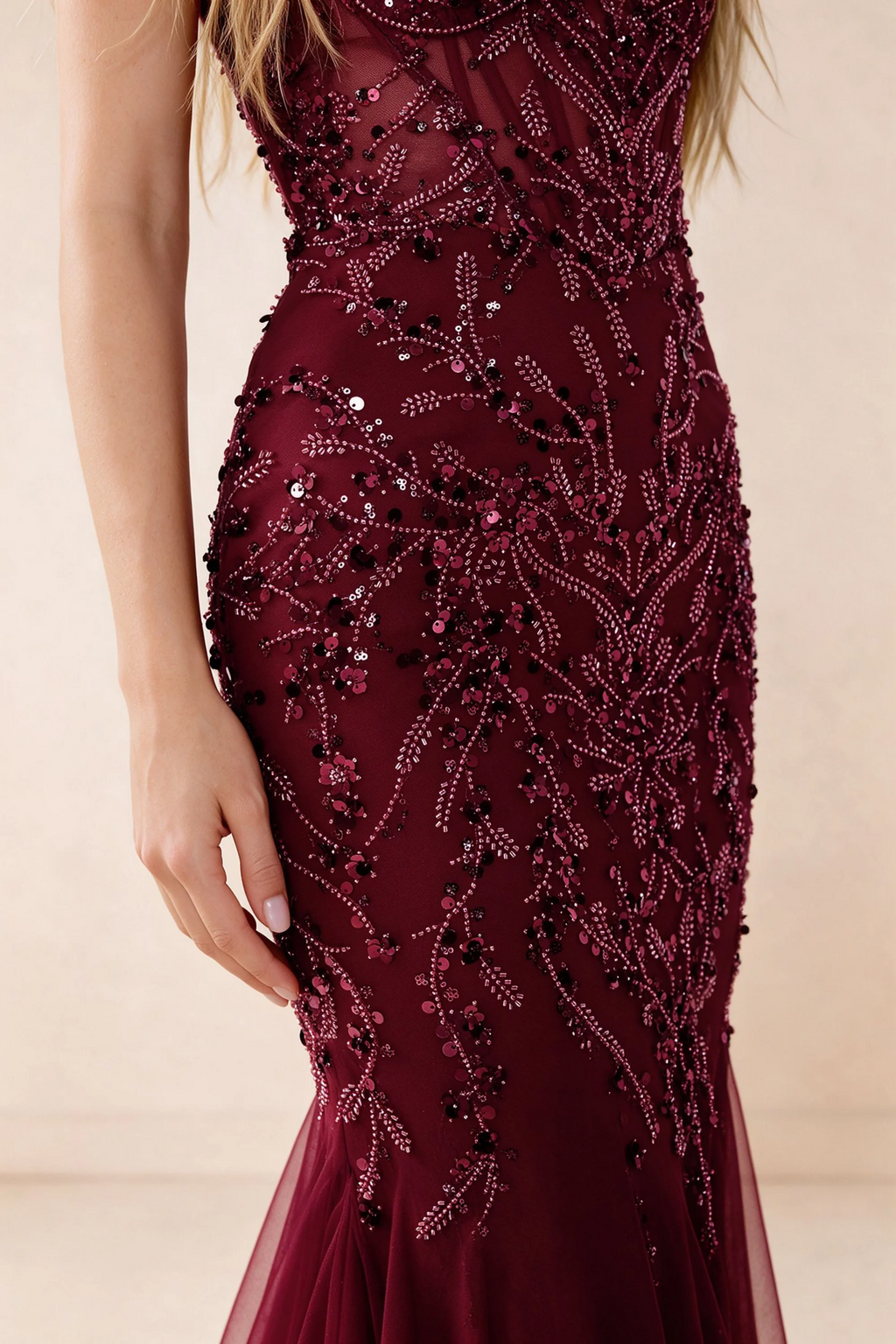 Detail of Aurelia burgundy embroidered sequin pattern across the fitted waist and hip