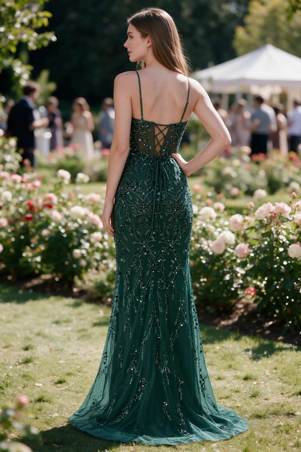 Rear garden view of Aurelia dark green mermaid dress with an open upper back and lace-up waist
