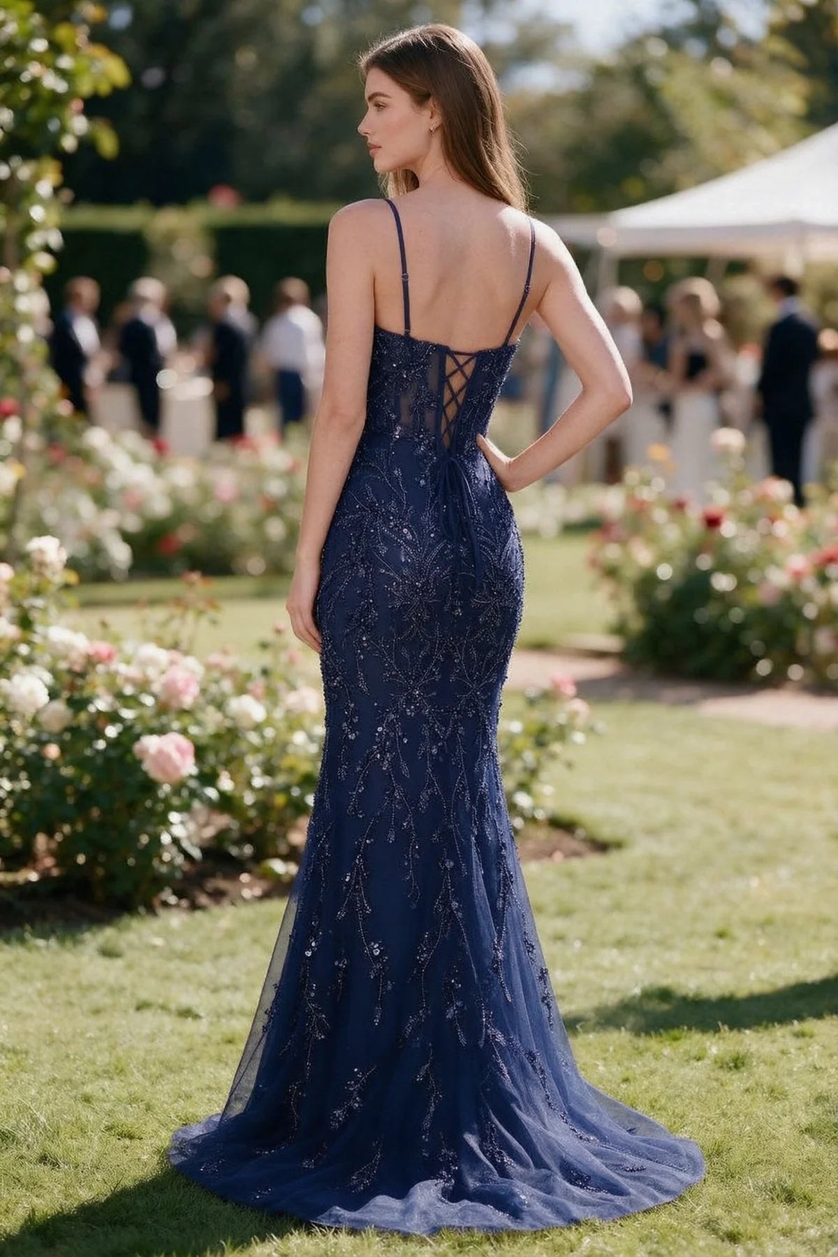 Rear garden view of Aurelia navy mermaid dress with an open upper back and lace-up waist