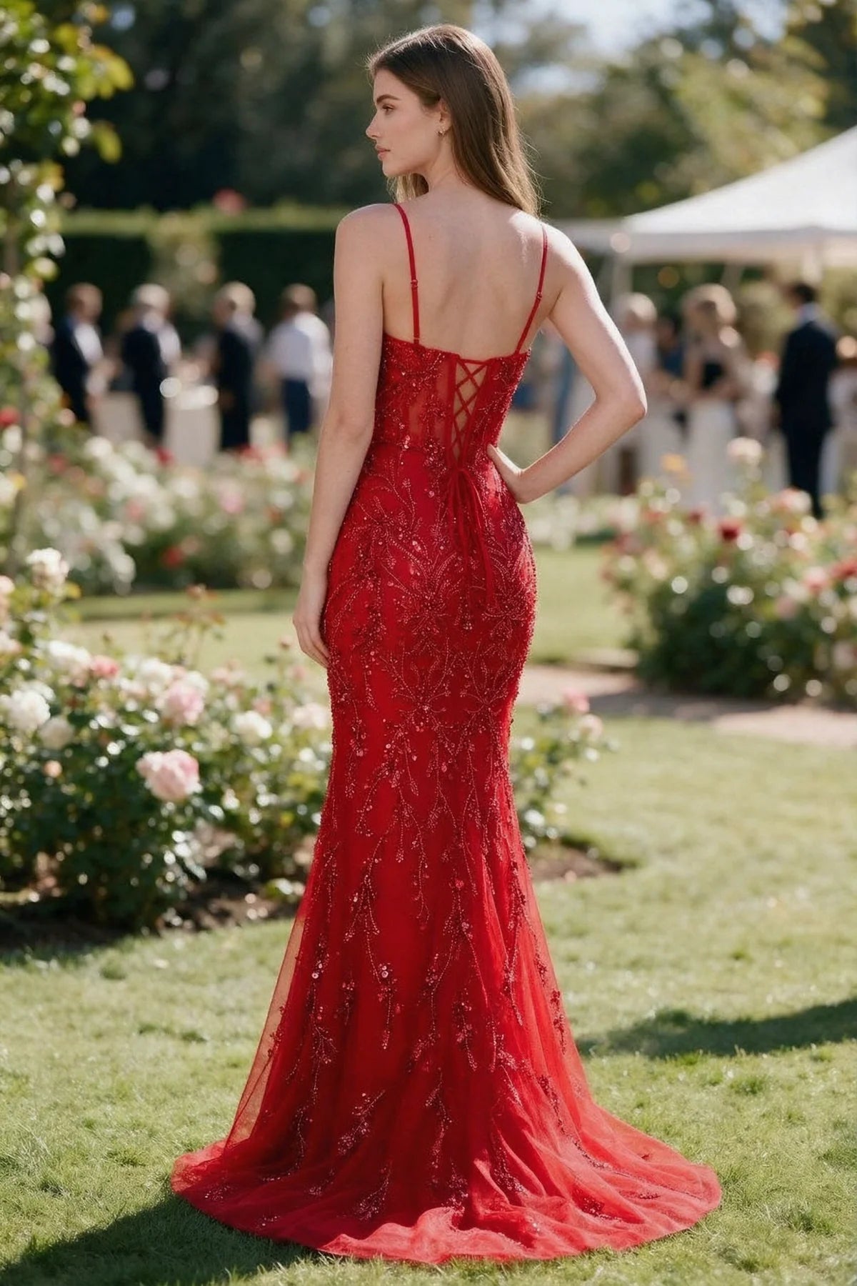 Rear garden view of Aurelia red mermaid dress with an open upper back and lace-up waist