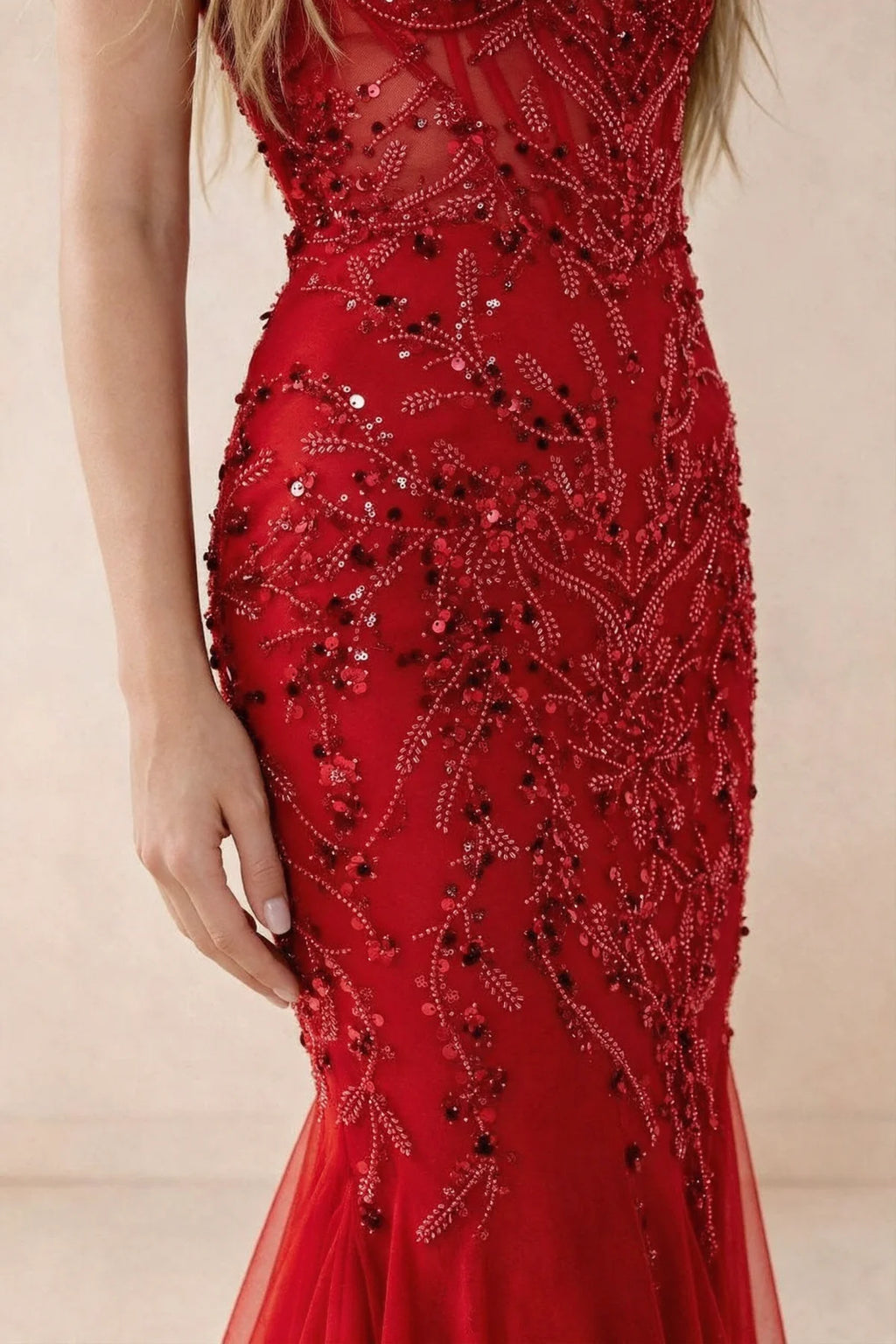Detail of Aurelia red embroidered sequin pattern across the fitted waist and hip