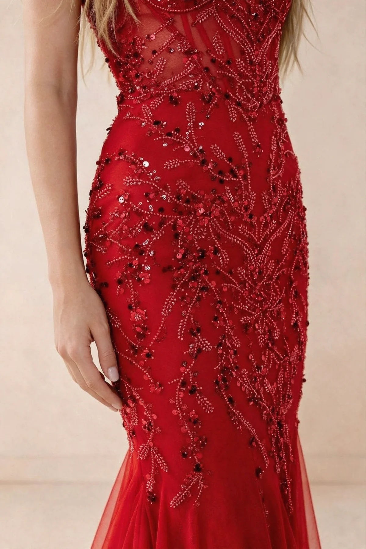 Detail of Aurelia red embroidered sequin pattern across the fitted waist and hip