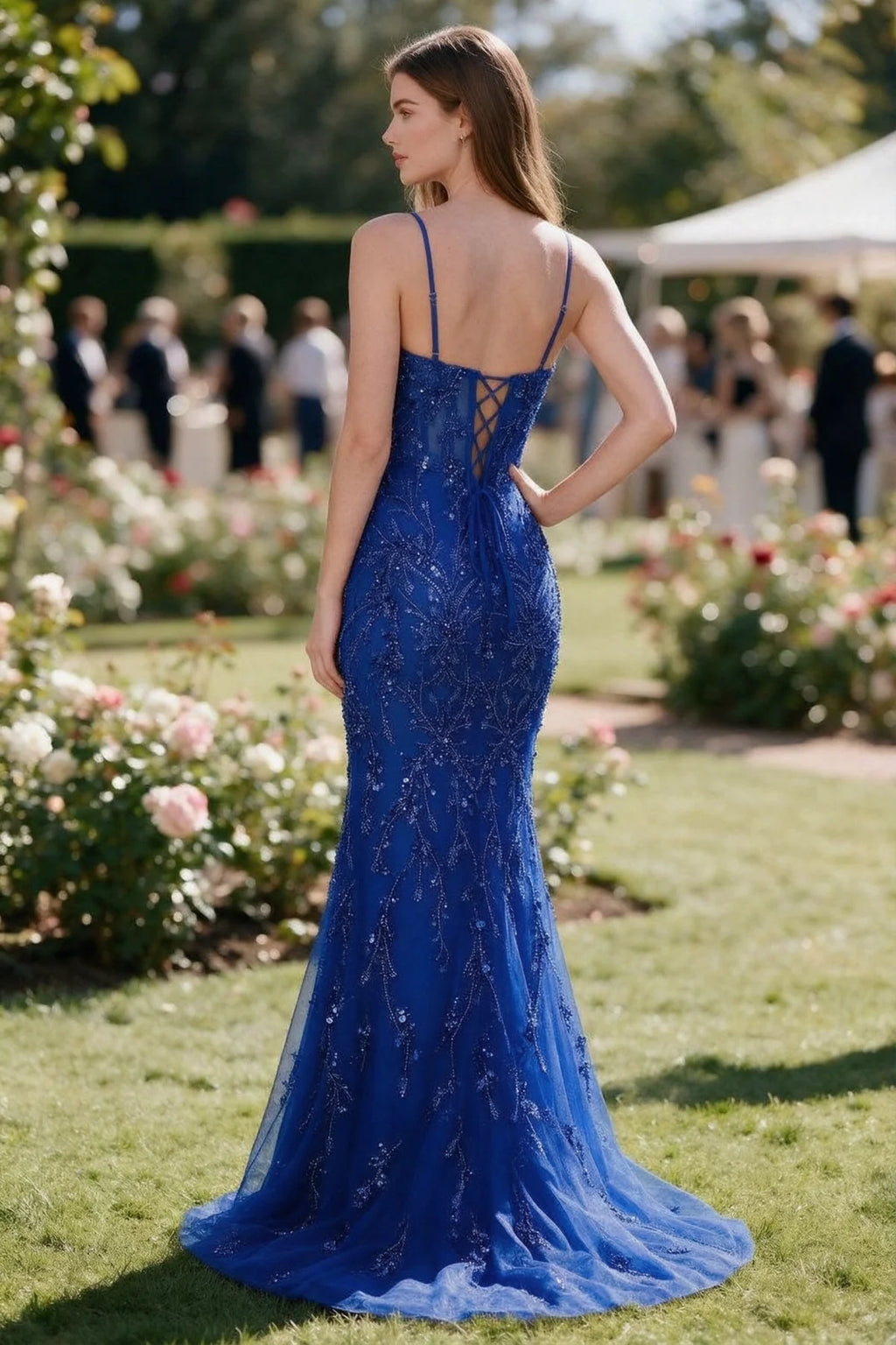 Rear garden view of Aurelia royal blue mermaid dress with an open upper back and lace-up waist