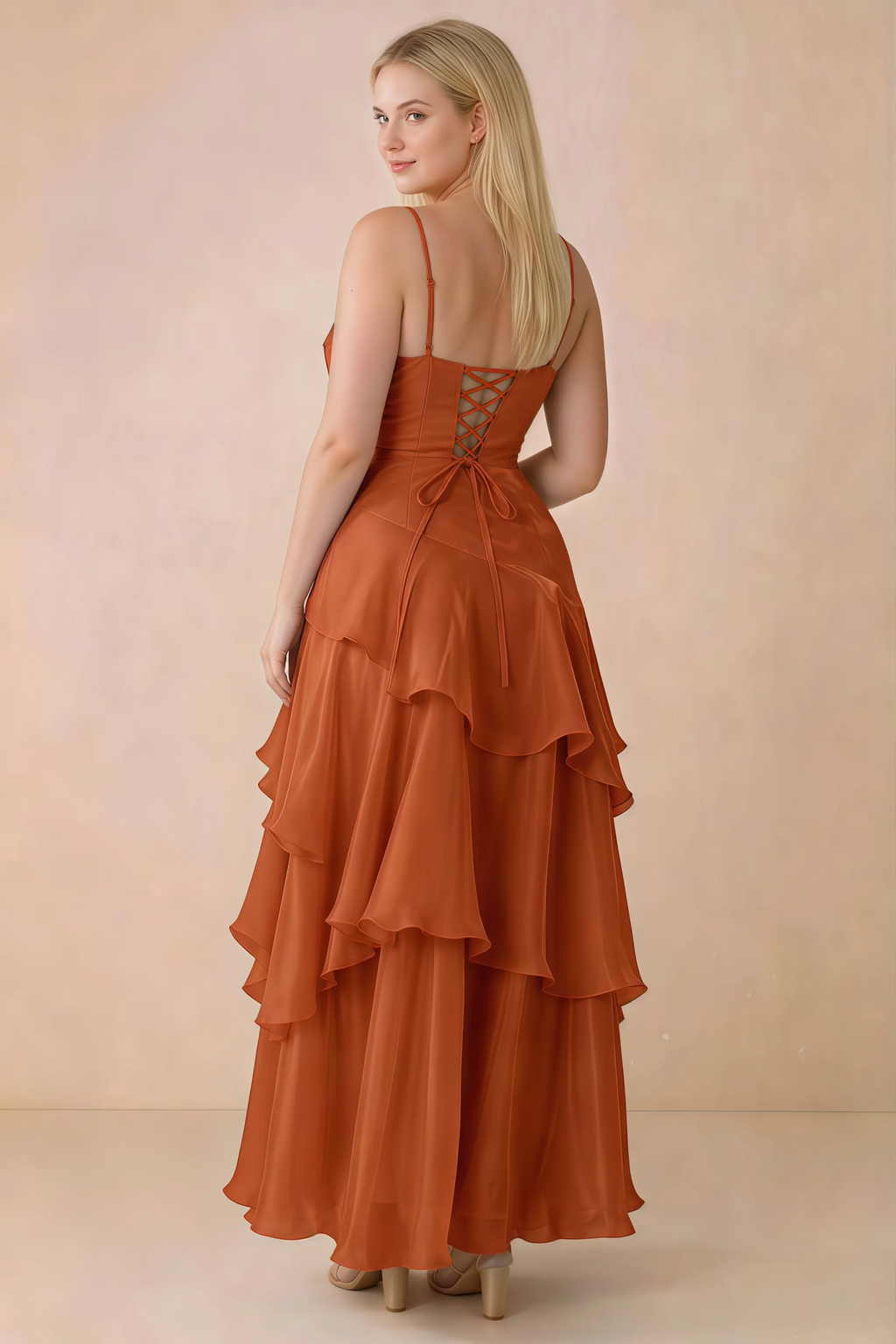 Rear studio view of Ava burnt orange maxi dress showing the lace-up bodice and long tiered skirt