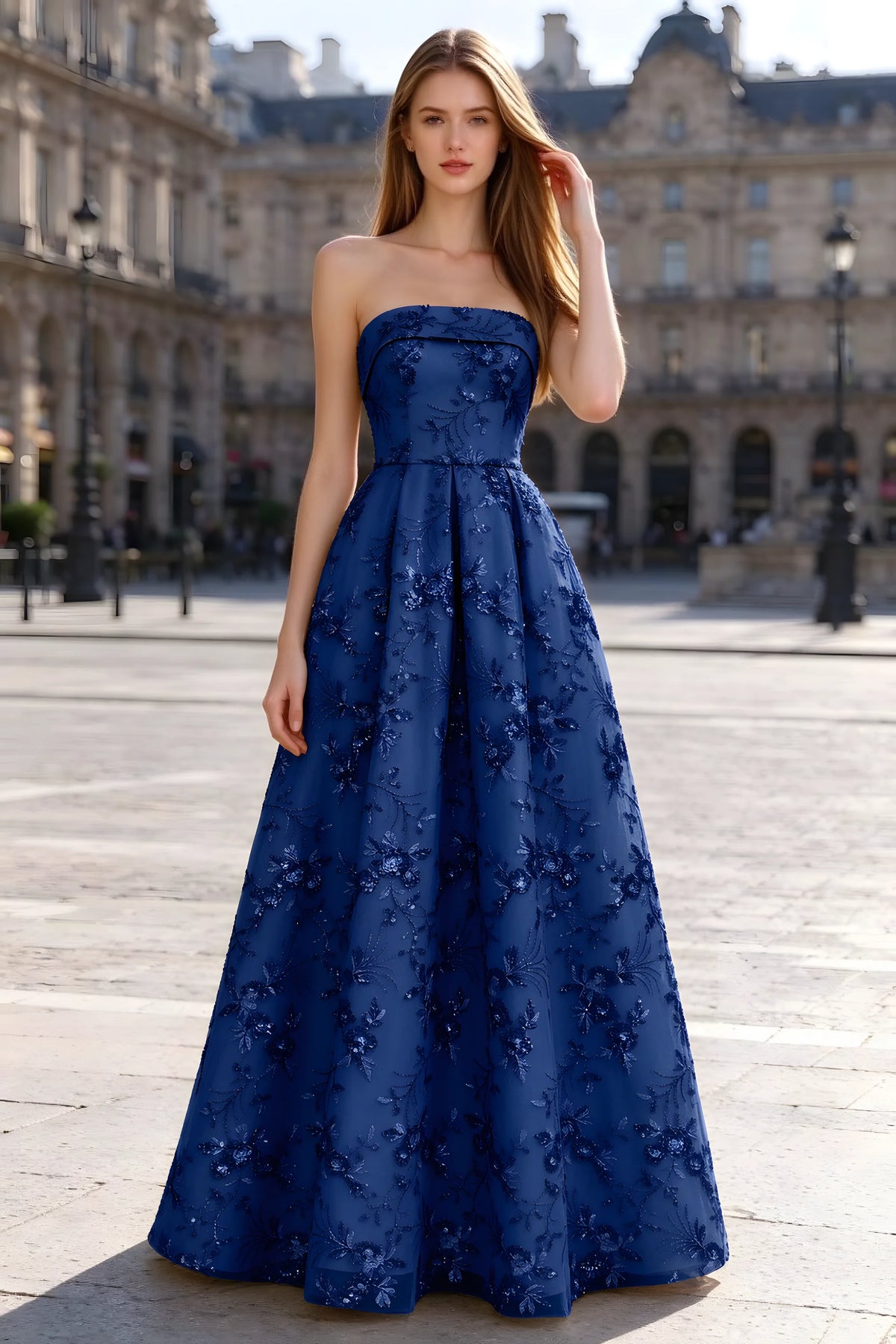 Avis royal blue floral sequin A-line maxi dress shown from the front in a stone courtyard