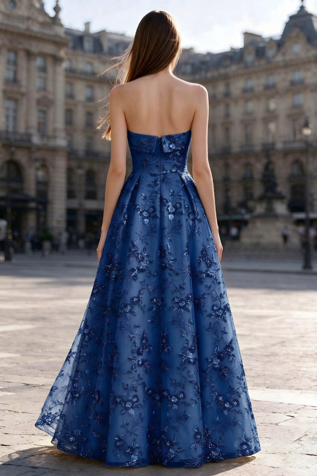 Rear courtyard view of Avis royal blue strapless maxi dress and wide pleated skirt