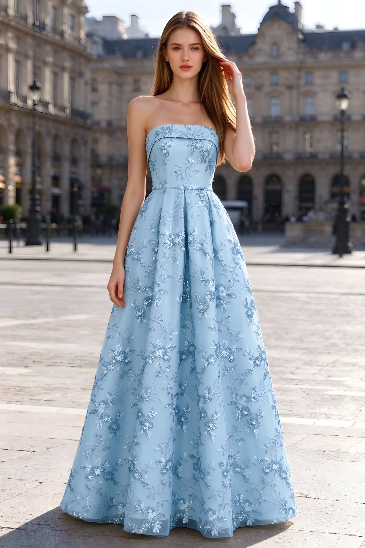 Avis sky blue floral sequin A-line maxi dress shown from the front in a stone courtyard