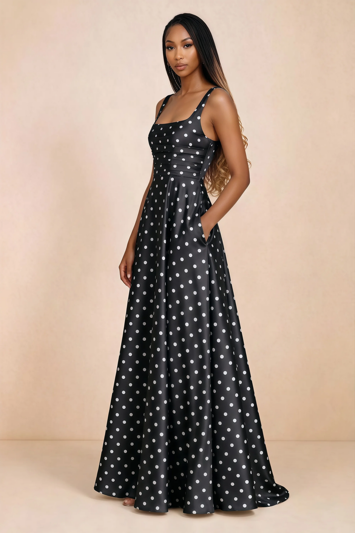 Three-quarter studio view of Becky black polka dot satin maxi dress with a hand resting in the side pocket