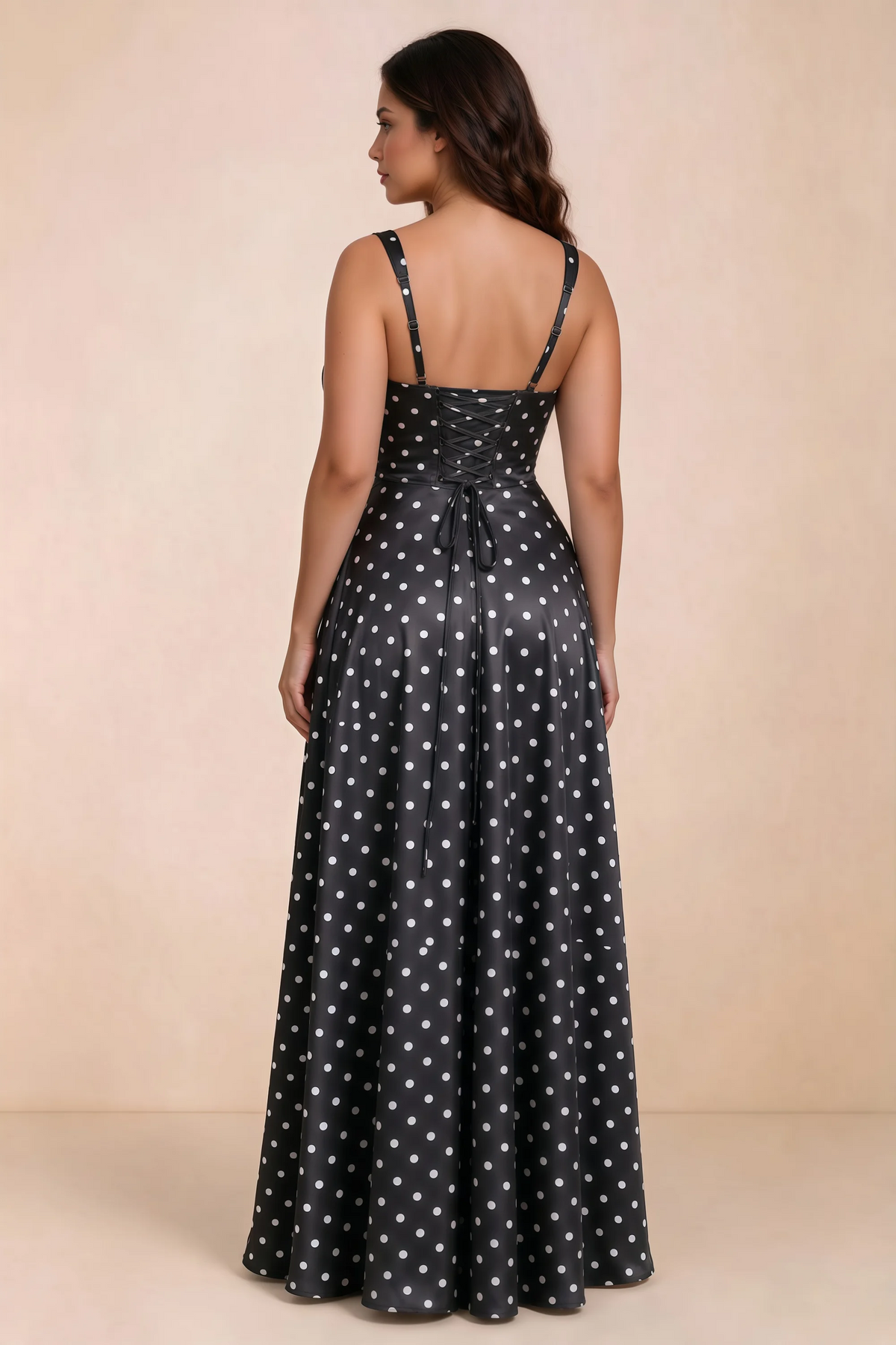 Rear studio view of Becky black polka dot satin maxi dress showing crossed back lacing above the full skirt