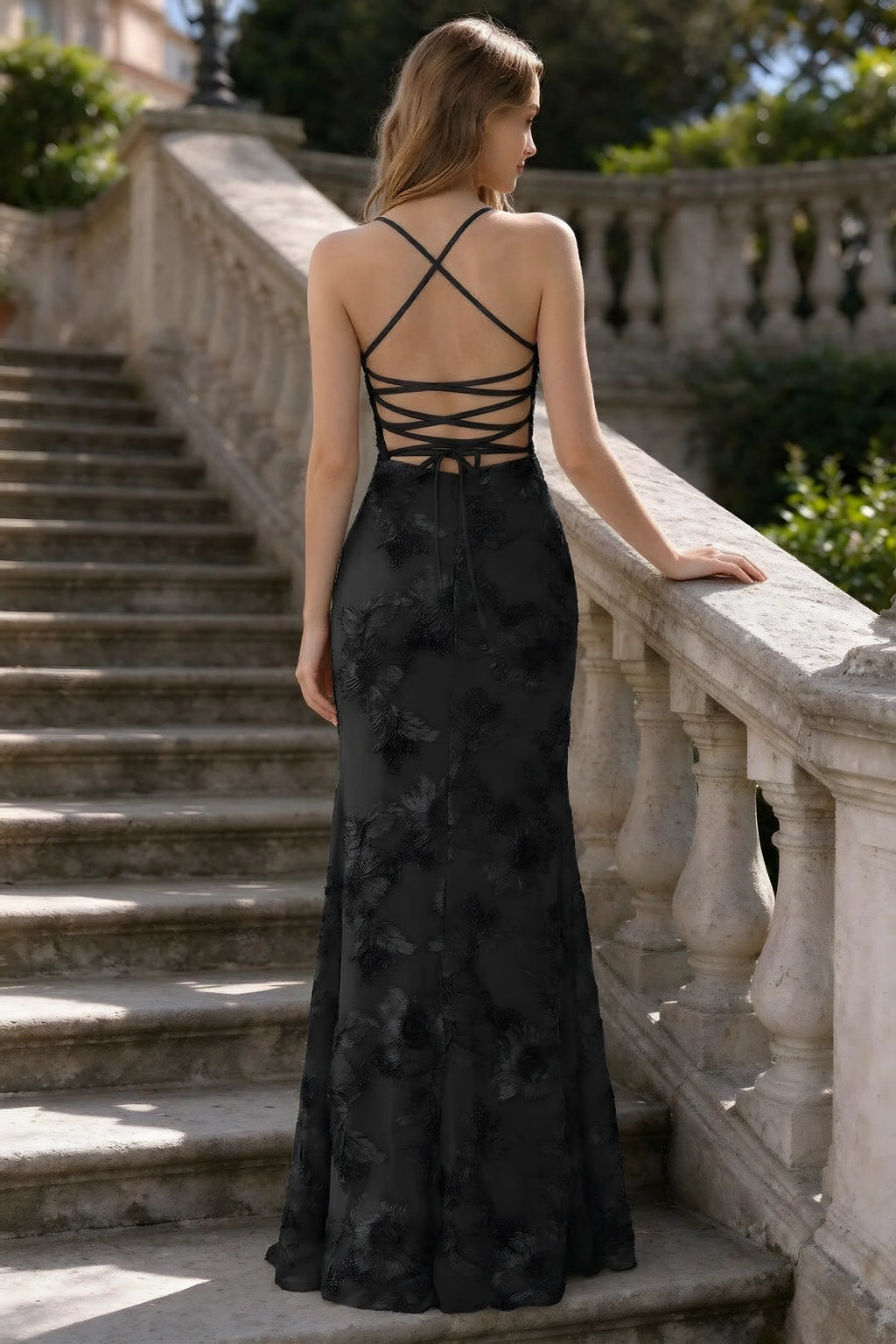 Outdoor rear view of Belinda black mermaid maxi dress showing the crisscross back ties