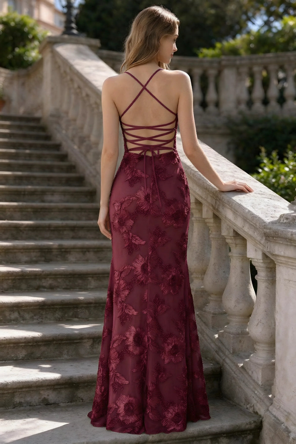 Outdoor rear view of Belinda burgundy mermaid maxi dress showing the crisscross back ties