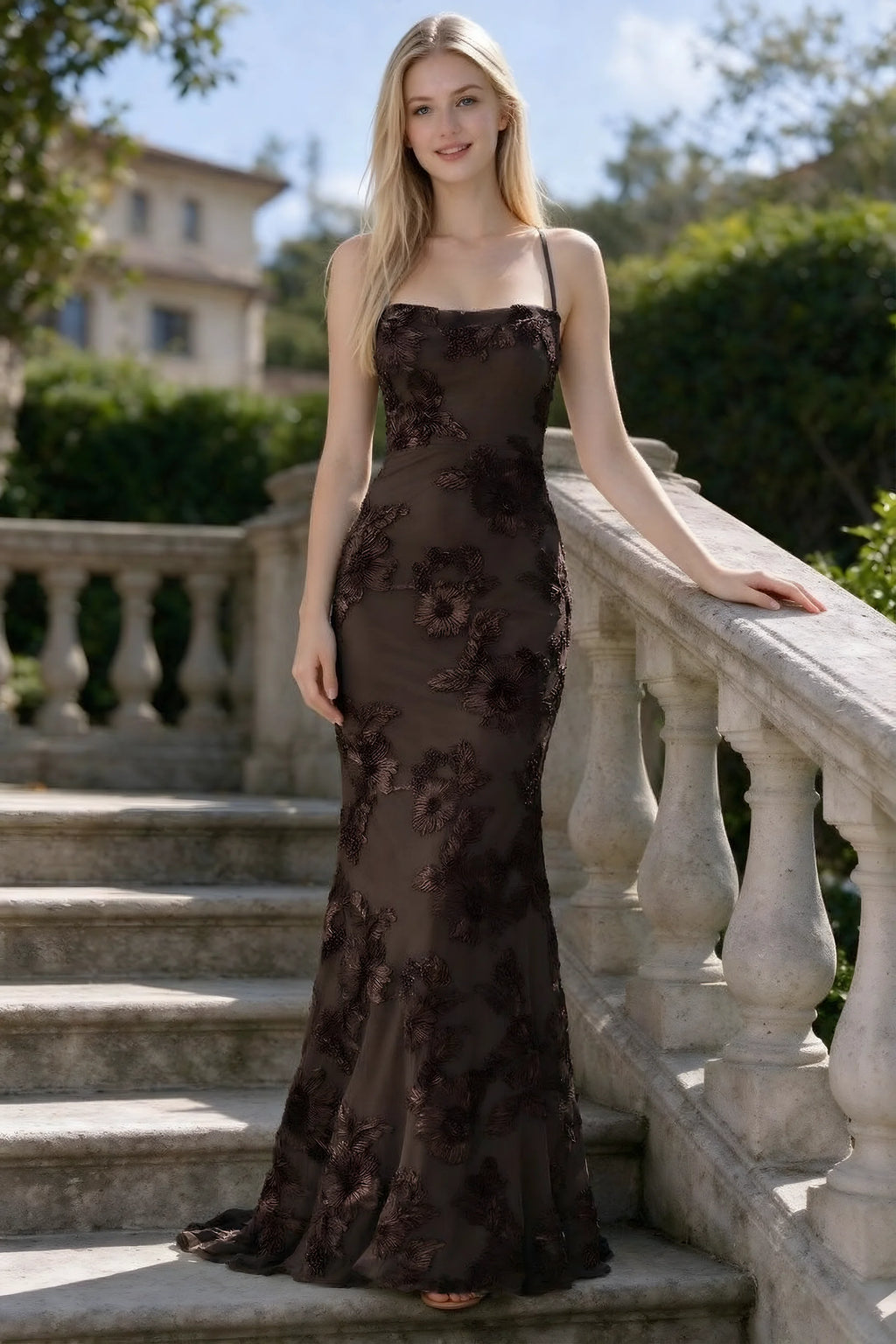 Outdoor front view of Belinda chocolate floral lace mermaid dress on stone steps