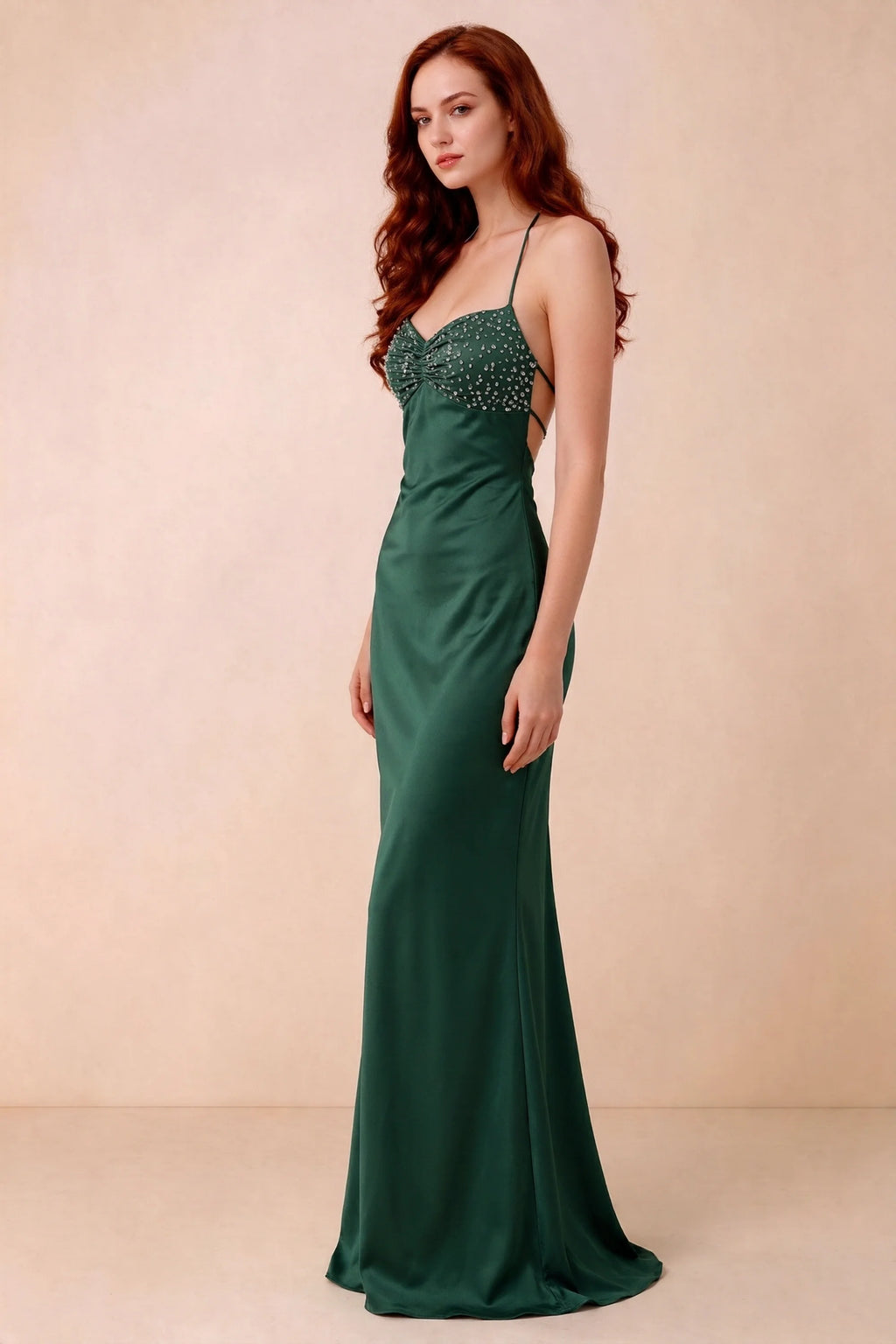Three-quarter studio view of Blanche emerald green dress showing the fitted hips and flared long hem