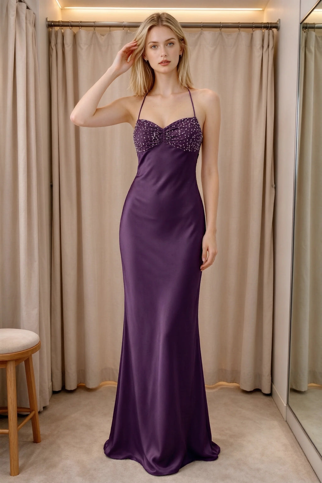 Front indoor view of Blanche grape satin maxi dress beside curtains with a beaded bust panel