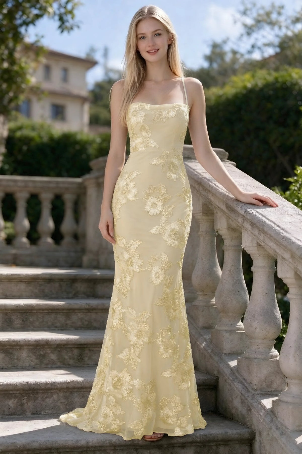 Outdoor front view of Belinda lemon floral lace mermaid dress on stone steps