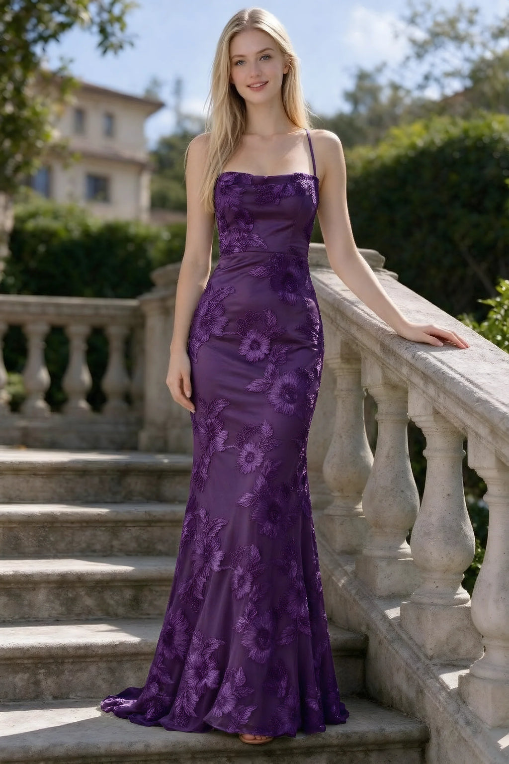 Outdoor front view of Belinda plum floral lace mermaid dress on stone steps