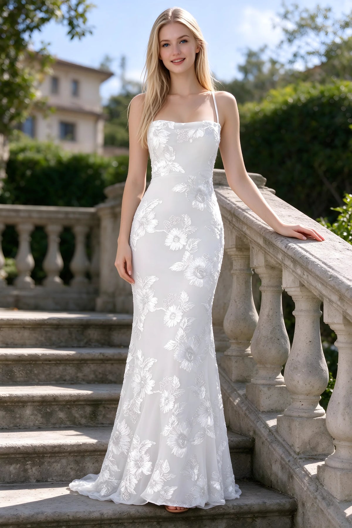Outdoor front view of Belinda white floral lace mermaid dress on stone steps