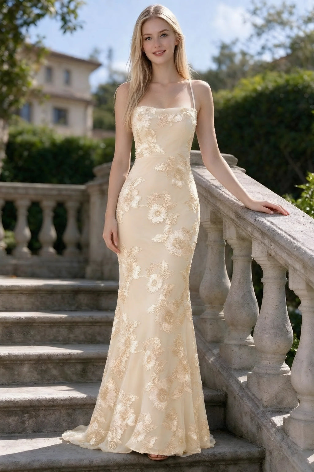 Outdoor front view of Belinda yellow floral lace mermaid dress on stone steps