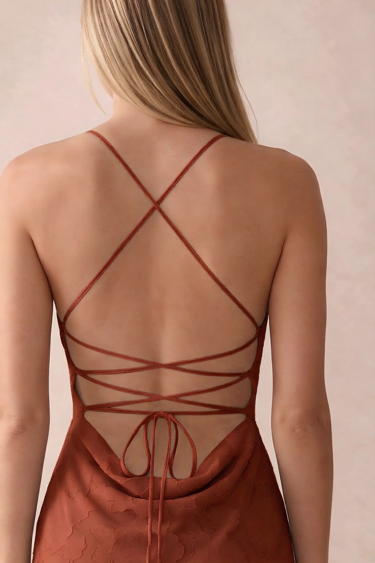 Close-up of Bess auburn open back with crossed straps, tie fastening and low cowl drape