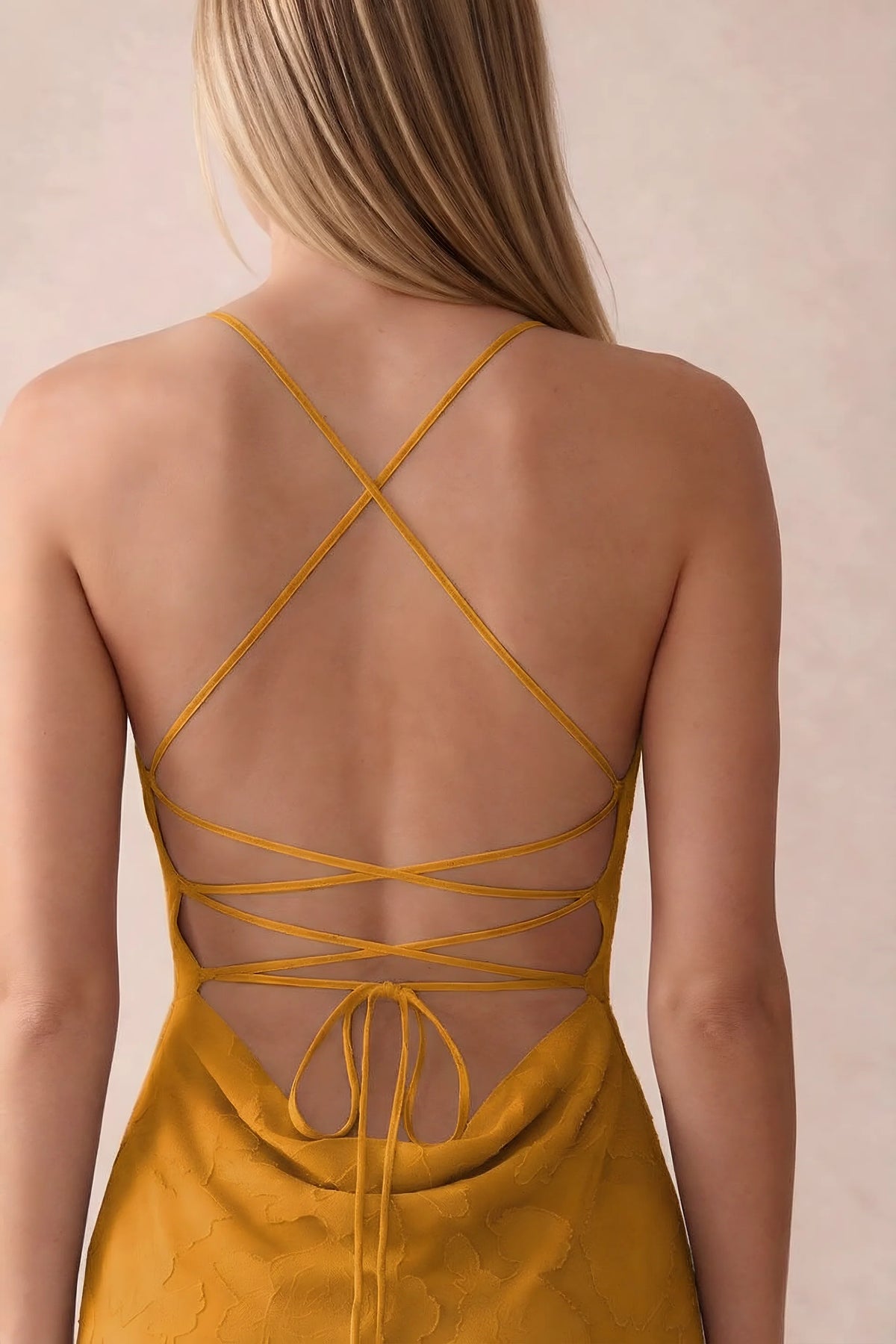Close-up of Bess butterscotch open back with crossed straps, tie fastening and low cowl drape