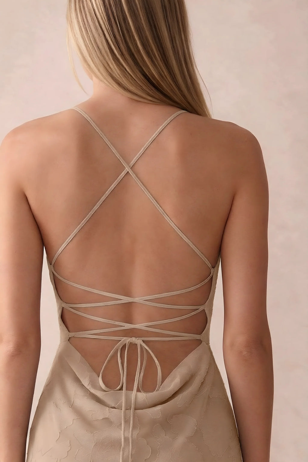 Close-up of Bess champagne open back with crossed straps, tie fastening and low cowl drape