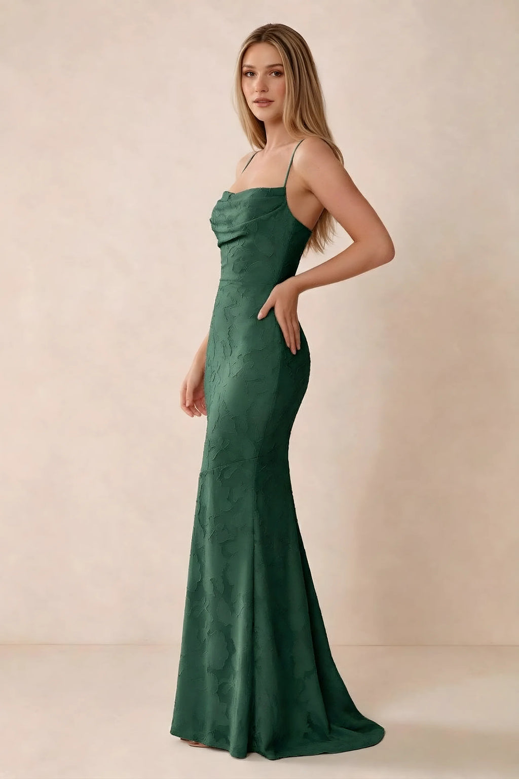 Three-quarter studio view of Bess emerald green dress showing the close-fitting waist and gently flared hem