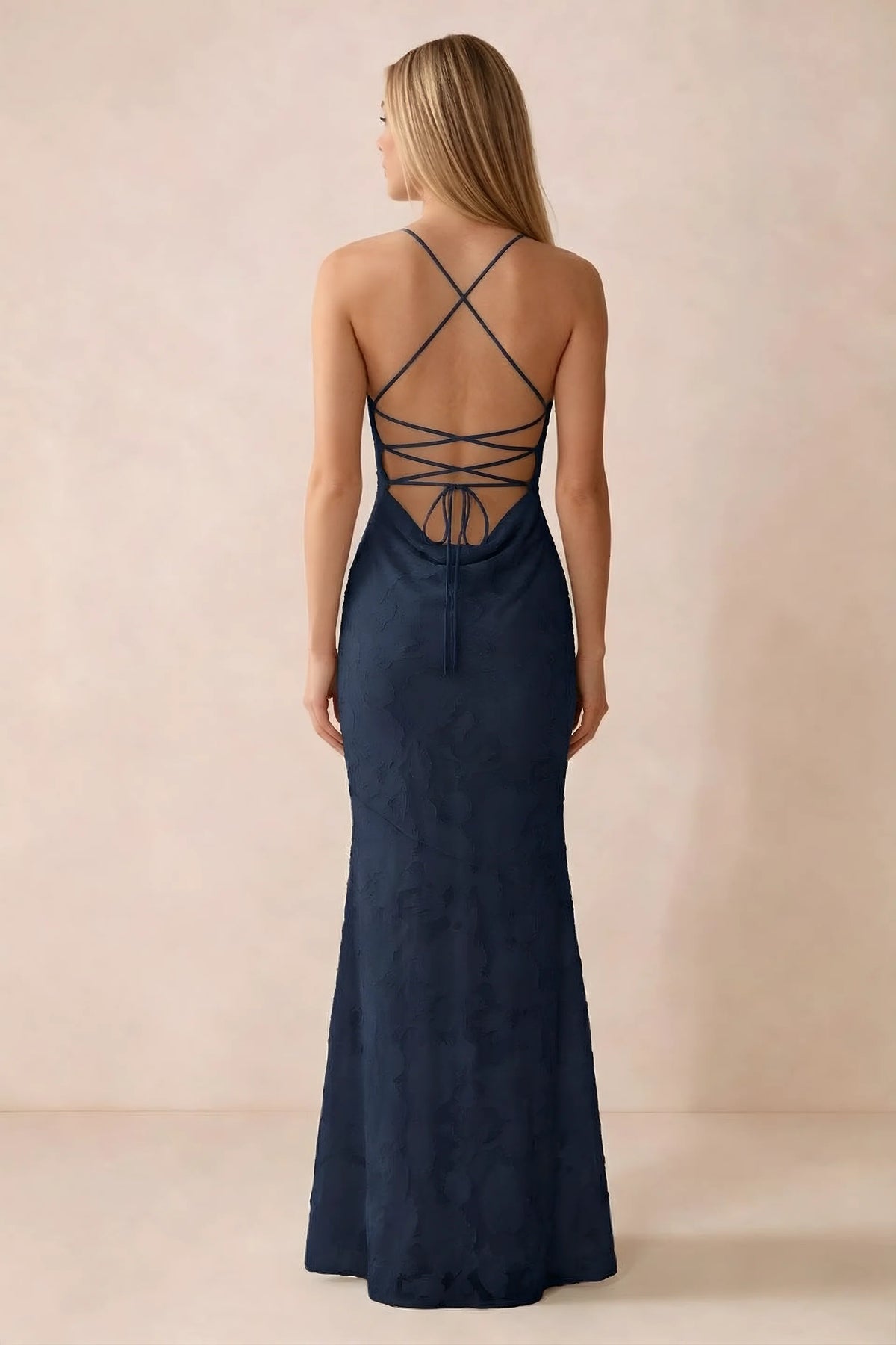 Rear studio view of Bess navy dress showing cross-back lacing above a low cowl drape
